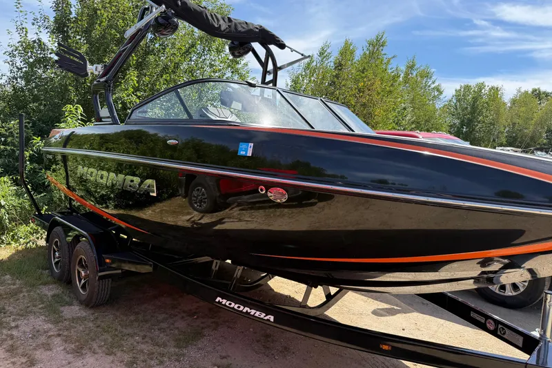 The Image of 2019 Moomba Craz boat in black with orange accents, parked on a trailer. - 0