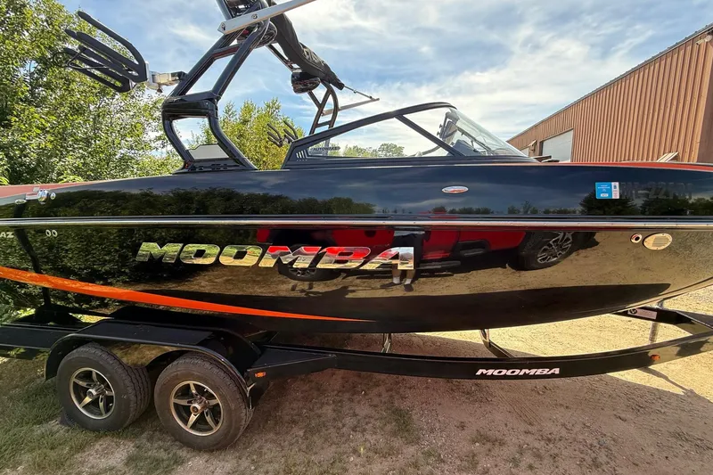 Slide: The Image of 2019 Moomba Craz boat on trailer, black exterior, parked outdoors. - 1