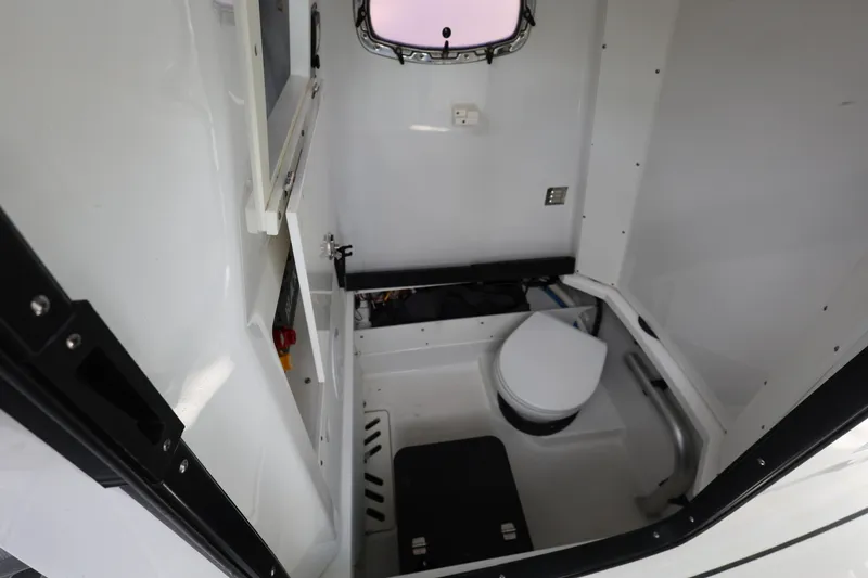 Slide: The Image of 2021 Blackfin 272 CC boat interior with compact marine toilet and window. - 21