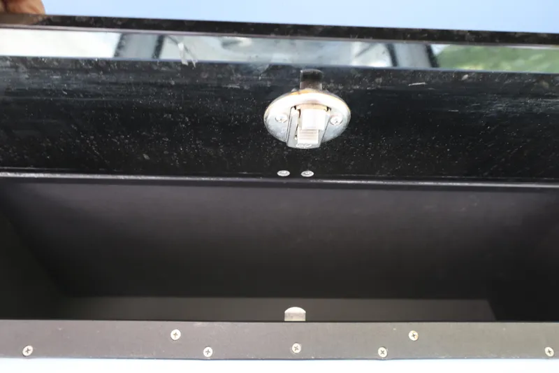 Slide: The Image of 2021 Blackfin 272 CC storage compartment with latch, open and empty. - 24
