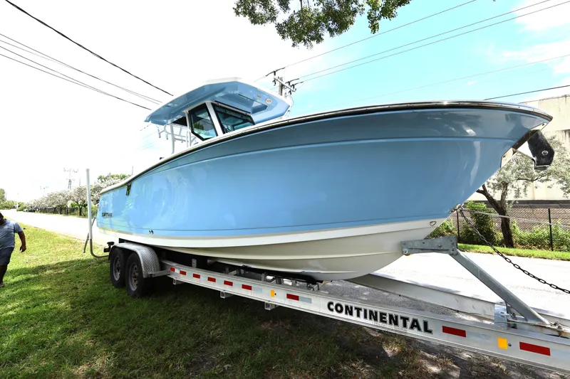 Slide: The Image of 2021 Blackfin 272 CC boat on trailer, parked outdoors on grass. - 4
