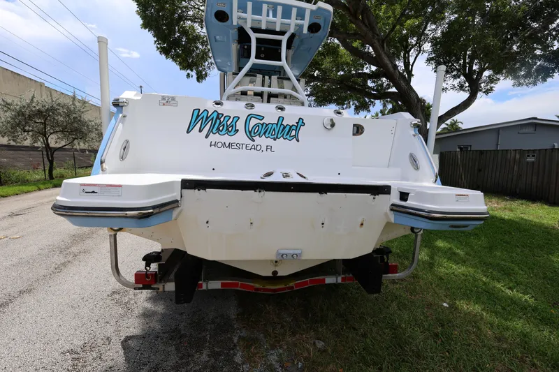 Slide: The Image of 2021 Blackfin 272 CC boat, rear view, parked on street, "Miss Conduct" text visible. - 8