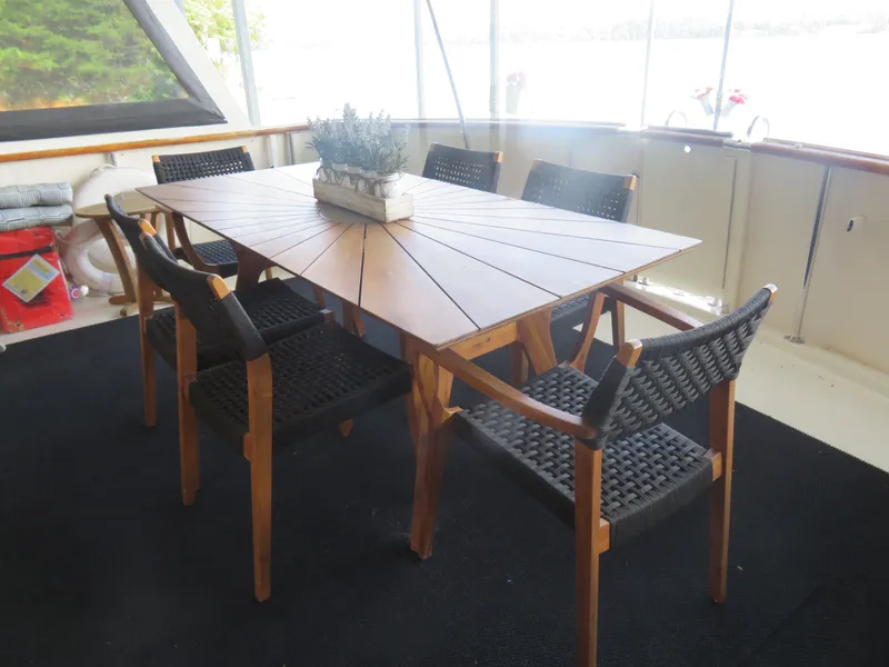 Slide: The Image of Elegant dining area on 1986 Hatteras 58 Motor Yacht with wooden table and chairs. - 10