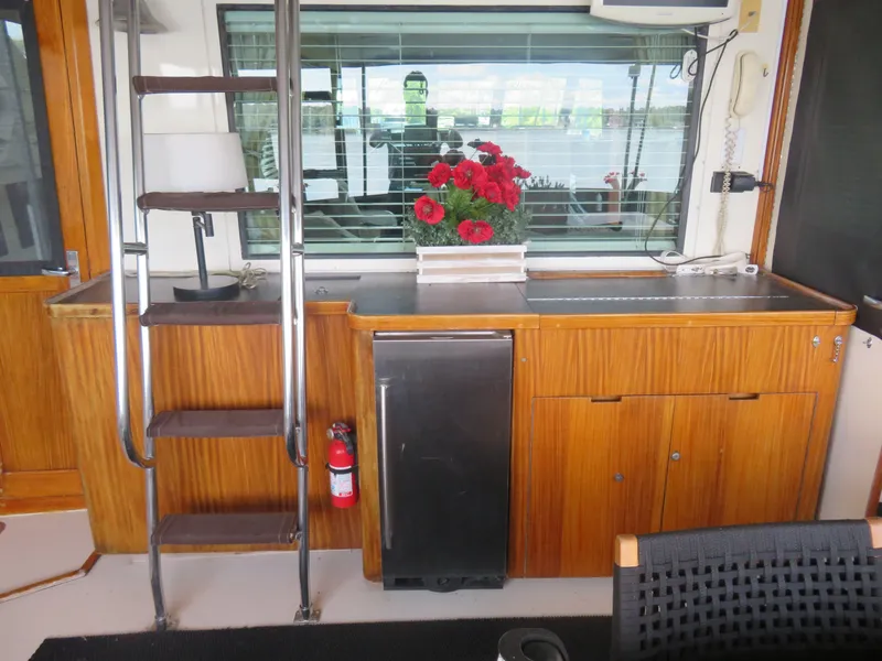 Slide: The Image of Interior of 1986 Hatteras 58 Motor Yacht with wooden cabinetry and red flowers. - 11
