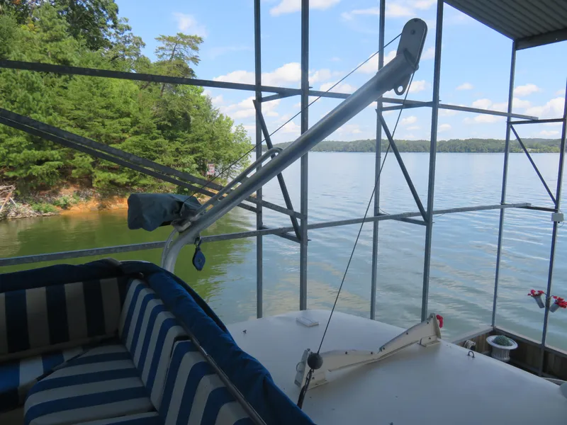 Slide: The Image of 1986 Hatteras 58 Motor Yacht docked by a scenic lake with lush greenery. - 17