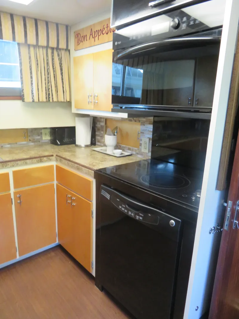 Slide: The Image of 1986 Hatteras 58 Motor Yacht kitchen with modern appliances and wooden cabinetry. - 22