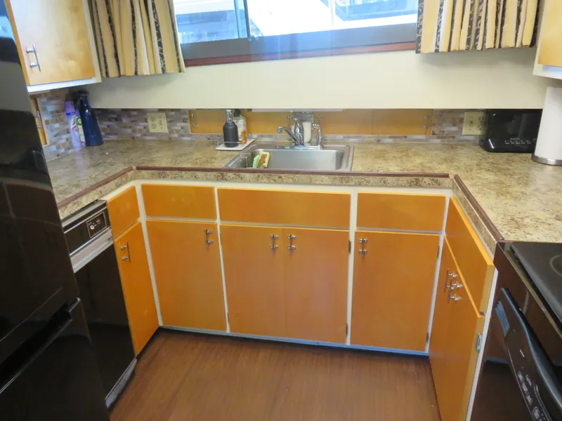 Slide: The Image of 1986 Hatteras 58 Motor Yacht kitchen with wood cabinets, granite countertops, and stainless steel sink. - 23