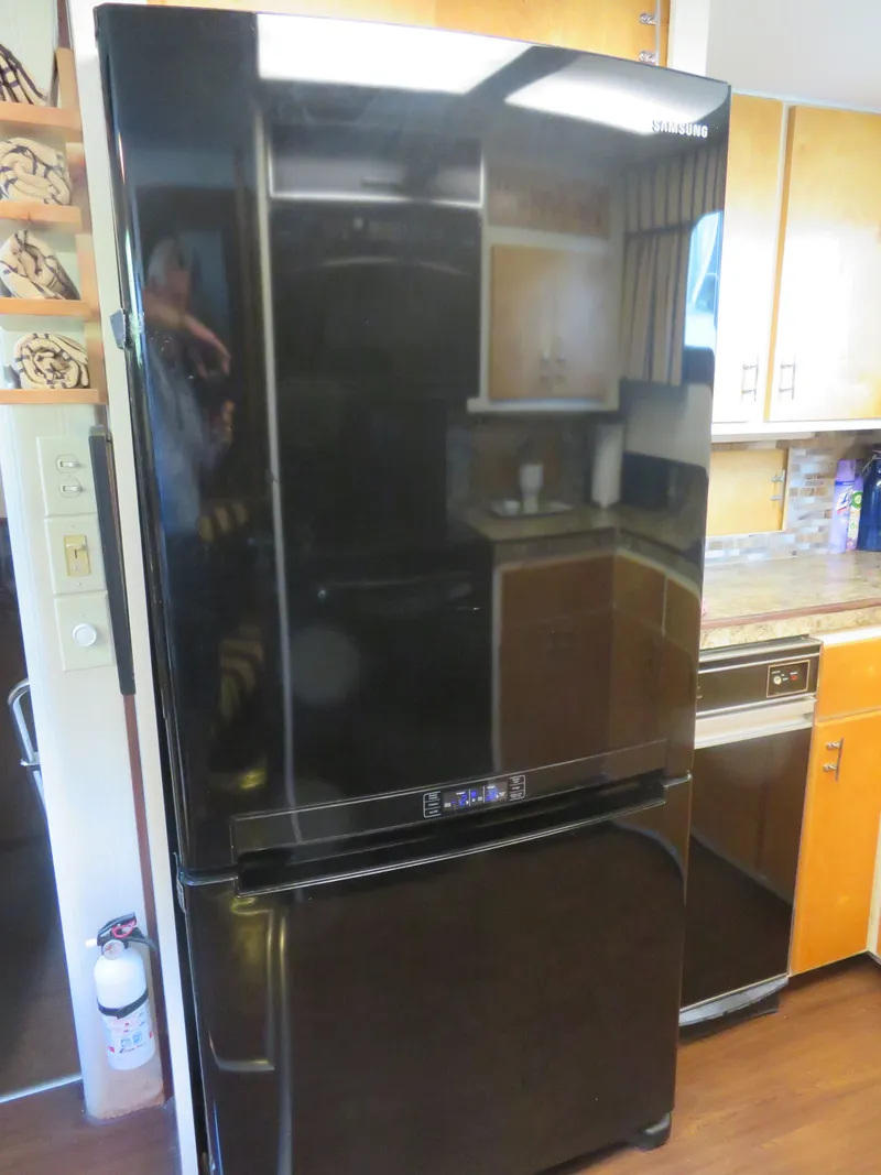Slide: The Image of Black Samsung refrigerator in the kitchen of a 1986 Hatteras 58 Motor Yacht. - 24
