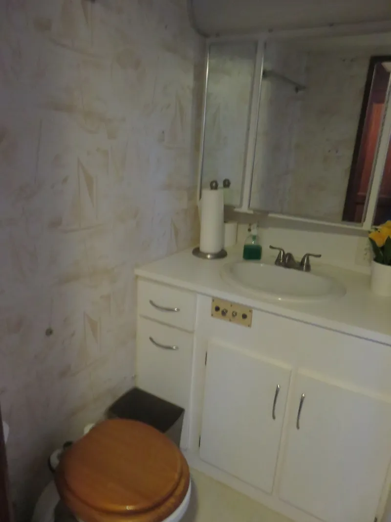 Slide: The Image of Bathroom interior of 1986 Hatteras 58 Motor Yacht with sink and wooden toilet seat. - 26