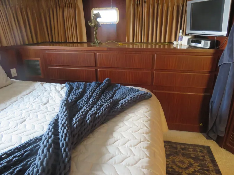 Slide: The Image of Luxurious bedroom interior of 1986 Hatteras 58 Motor Yacht with cozy bedding and elegant wood cabinetry. - 36