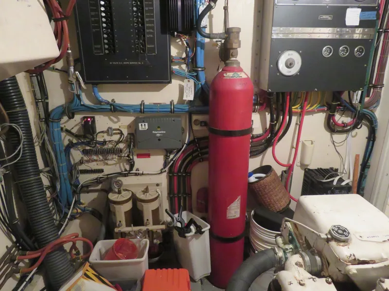 Slide: The Image of Engine room of 1986 Hatteras 58 Motor Yacht with wiring, control panels, and fire extinguisher. - 39