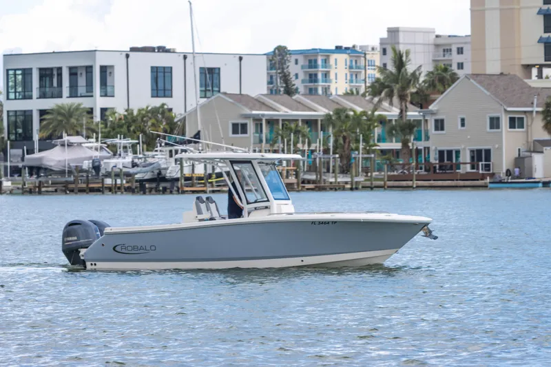 Slide: The Image of 2023 Robalo R250 Center Console boat cruising near waterfront homes. - 15