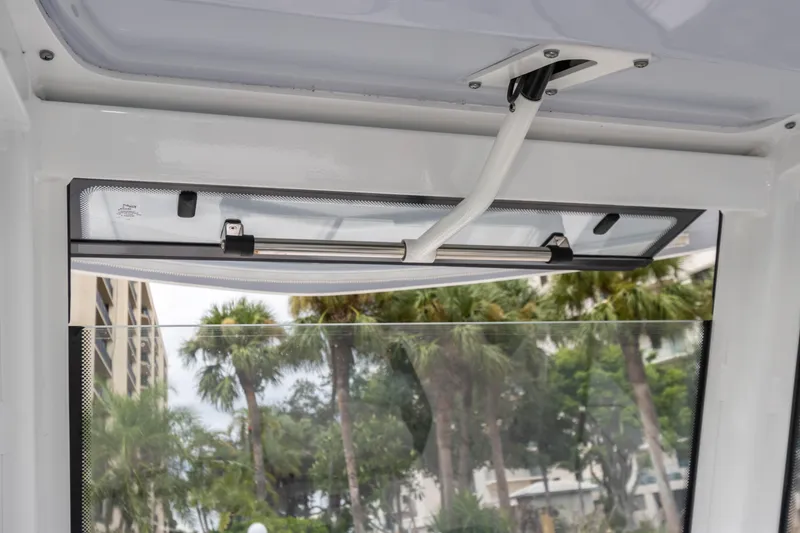 Slide: The Image of 2023 Robalo R250 Center Console window detail with palm trees in the background. - 31