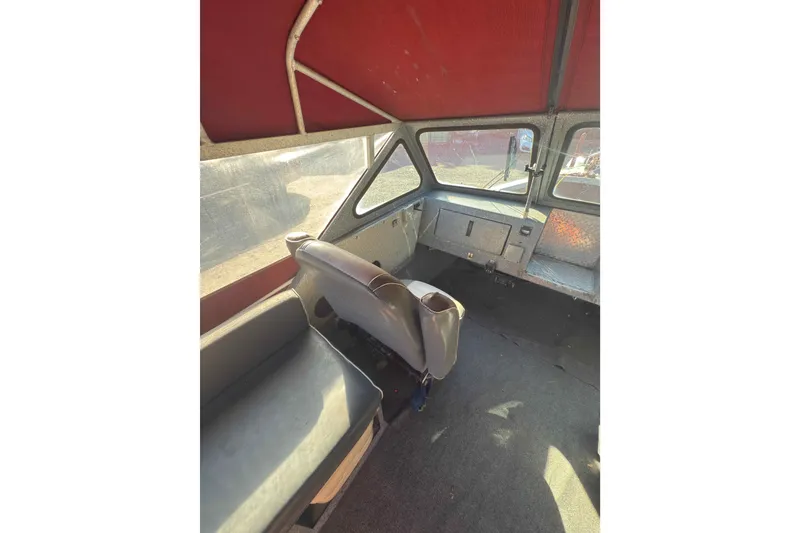 Slide: The Image of Interior of a 1991 Fish Rite 22 Custom boat with red canopy and seating. - 12