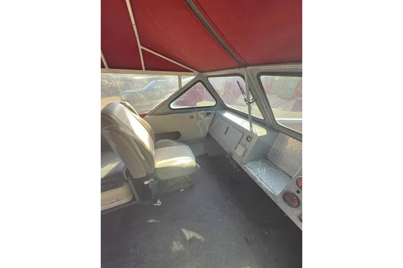 Slide: The Image of Interior of a 1991 Fish Rite 22 Custom boat with red canopy and seating. - 15