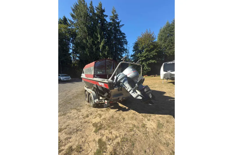 Slide: The Image of 1991 Fish Rite 22 Custom boat with outboard motor, parked outdoors on a sunny day. - 3