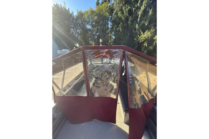 Slide: The Image of 1991 Fish Rite 22 Custom boat with red canopy, surrounded by trees. - 9