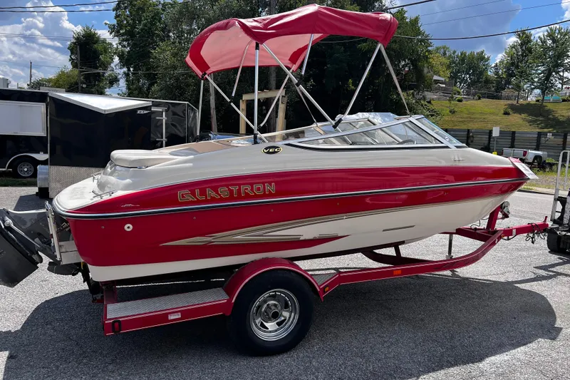 Slide: The Image of 2004 Glastron GX 185 boat with red and white design on a trailer. - 2