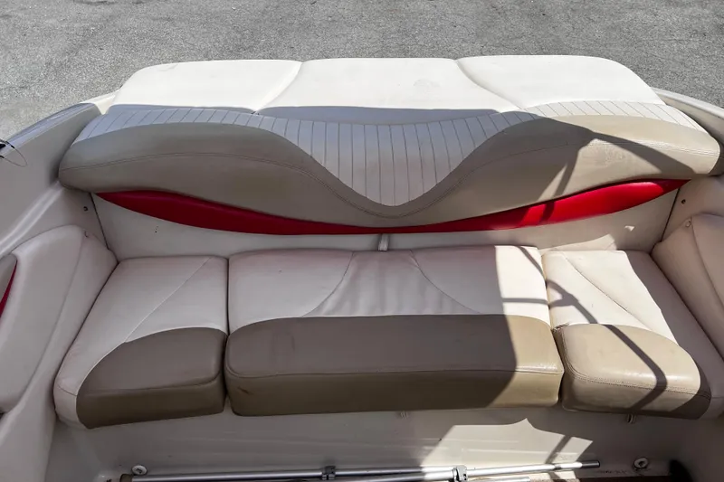 Slide: The Image of 2004 Glastron GX 185 boat interior seating with beige and red upholstery. - 6