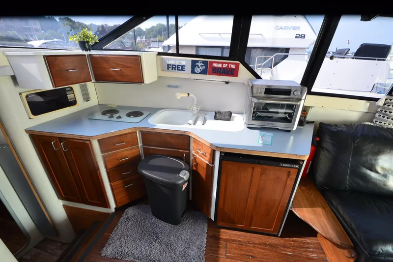 Slide: The Image of 1988 Mainship Mediterranean Convertible yacht kitchen with wooden cabinets and modern appliances. - 13