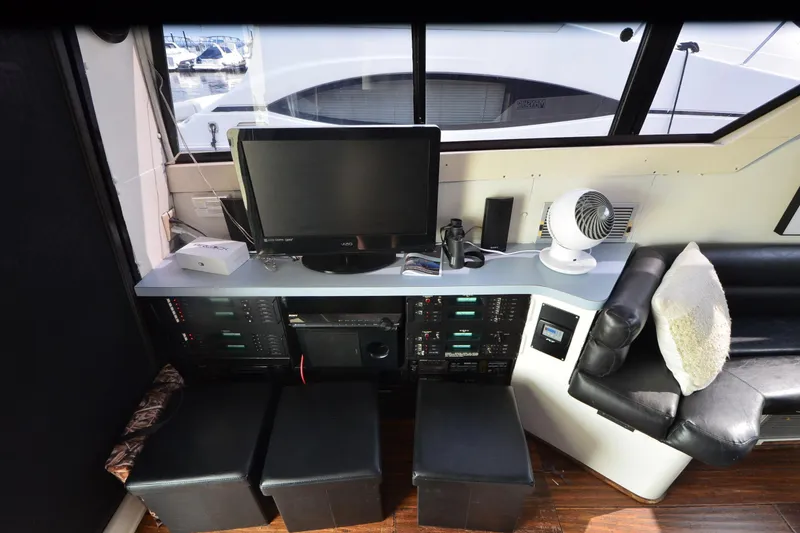 Slide: The Image of 1988 Mainship Mediterranean Convertible interior with TV, fan, and seating. - 14
