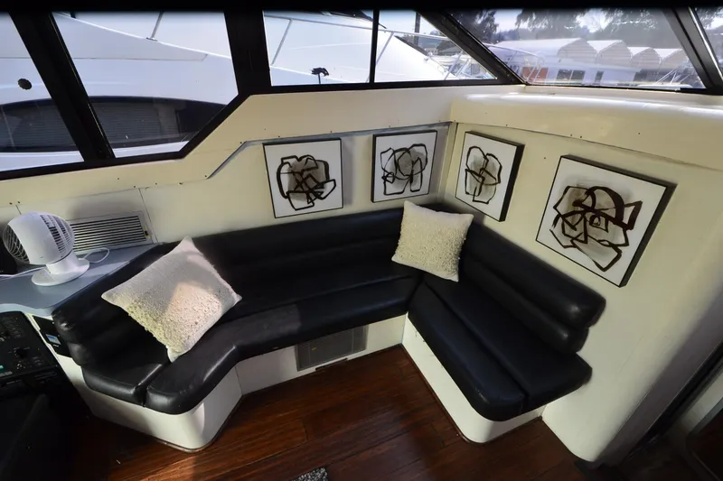 Slide: The Image of 1988 Mainship Mediterranean Convertible interior with black leather seating and abstract wall art. - 15