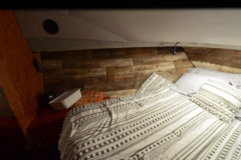 Slide: The Image of Cozy cabin interior of 1988 Mainship Mediterranean Convertible with wood paneling and striped bedding. - 18