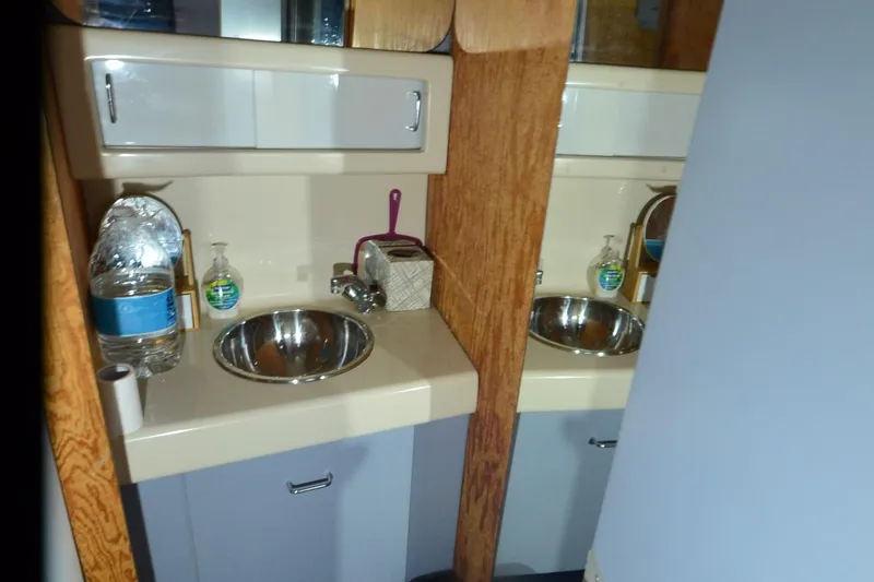 Slide: The Image of 1988 Mainship Mediterranean Convertible bathroom with sink, mirror, and toiletries. - 21