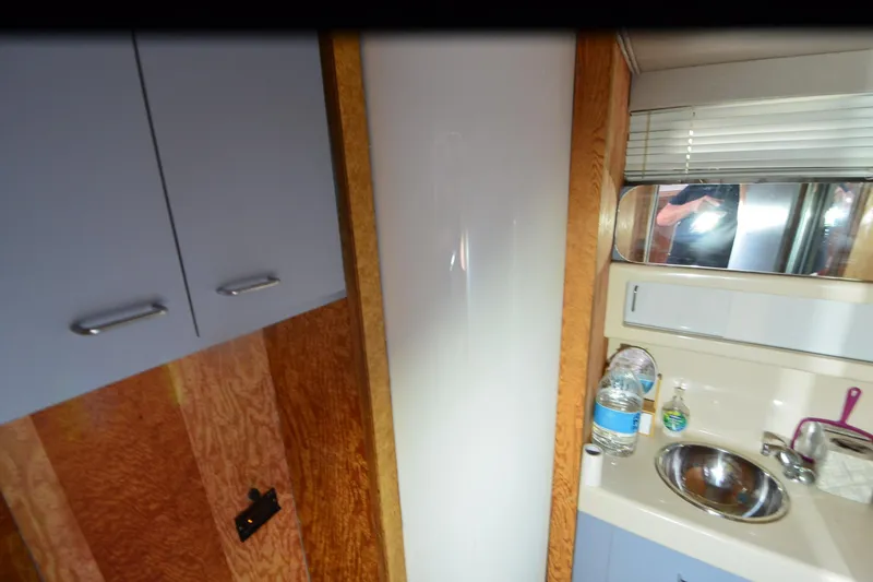 Slide: The Image of 1988 Mainship Mediterranean Convertible interior with sink, cabinets, and mirror. - 22