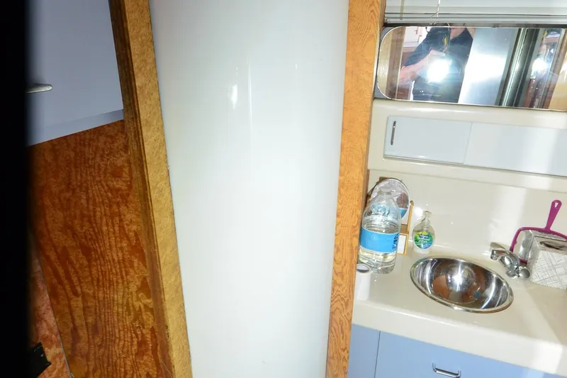 Slide: The Image of 1988 Mainship Mediterranean Convertible bathroom with sink, mirror, and toiletries. - 23