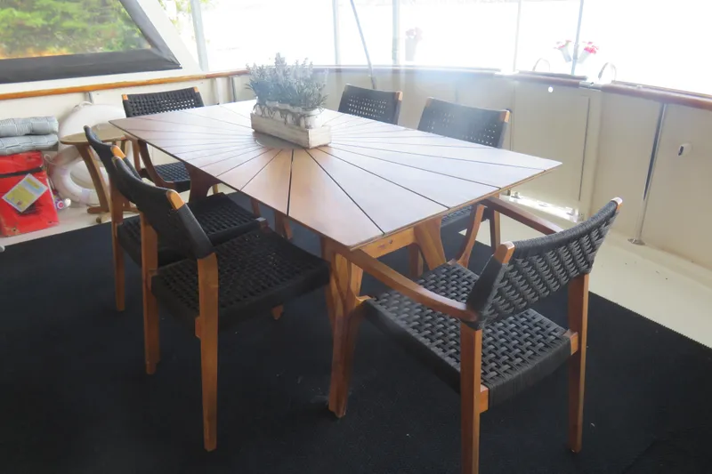 Slide: The Image of Elegant dining area on 1986 Hatteras 58 Motor Yacht with wooden table and chairs. - 12