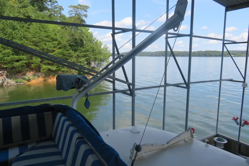 Slide: The Image of 1986 Hatteras 58 Motor Yacht docked by a scenic lake with lush greenery. - 18