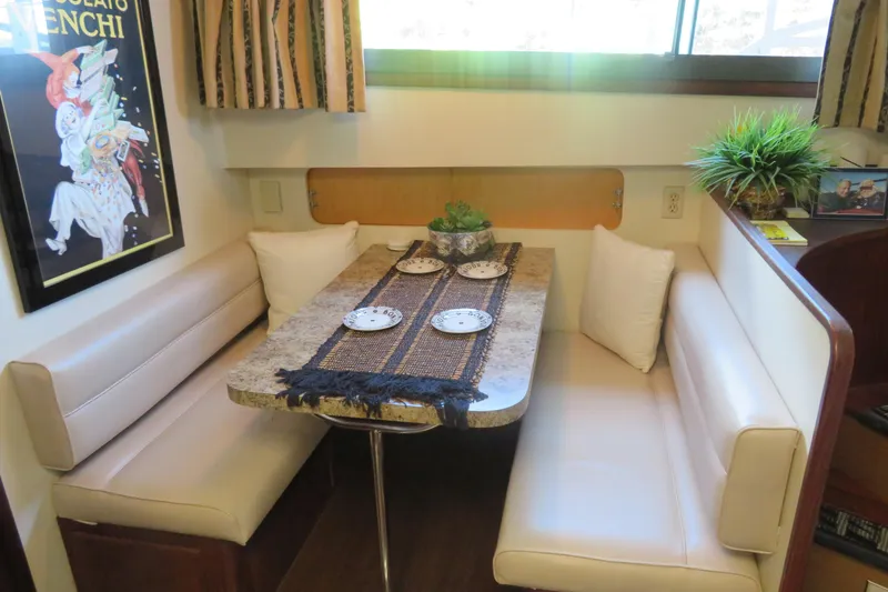 Slide: The Image of Cozy dining area in 1986 Hatteras 58 Motor Yacht with elegant decor and seating. - 22