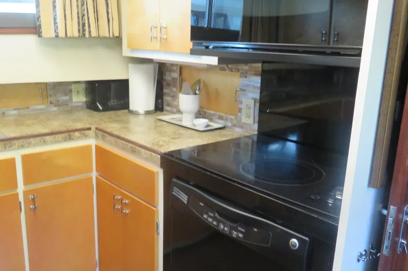 Slide: The Image of 1986 Hatteras 58 Motor Yacht kitchen with stove, cabinets, and countertop appliances. - 23