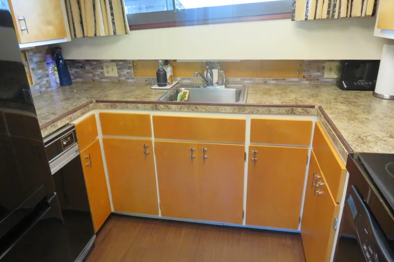 Slide: The Image of 1986 Hatteras 58 Motor Yacht kitchen with wooden cabinets and stainless steel sink. - 24