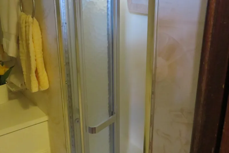 Slide: The Image of Shower area inside 1986 Hatteras 58 Motor Yacht, featuring glass door and towel rack. - 28