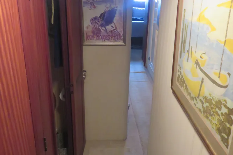 Slide: The Image of Hallway inside 1986 Hatteras 58 Motor Yacht with artwork and wooden cabinetry. - 29