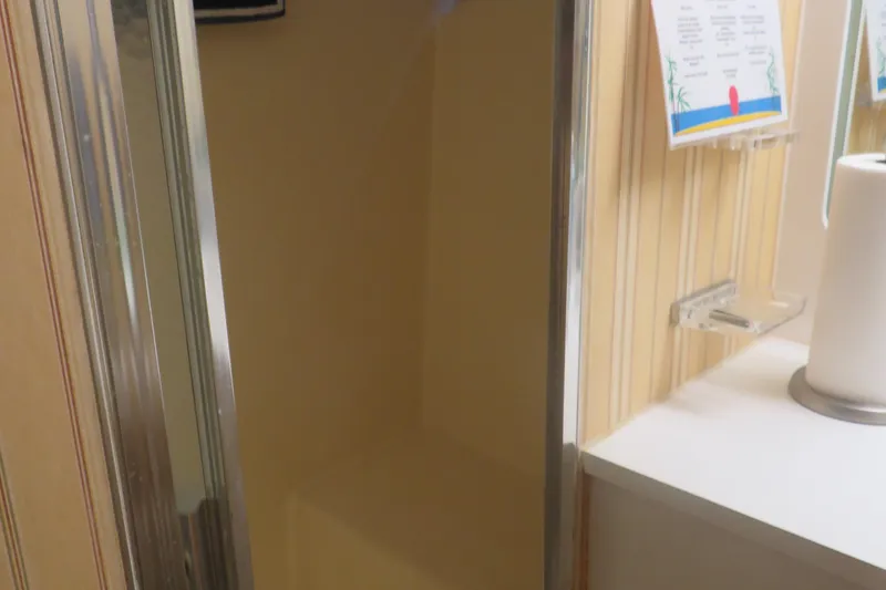 Slide: The Image of Shower area inside 1986 Hatteras 58 Motor Yacht with striped wallpaper and paper towel holder. - 31