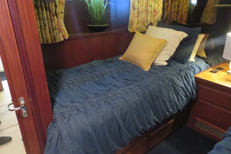 Slide: The Image of Cozy cabin interior of 1986 Hatteras 58 Motor Yacht with blue bedding and decorative pillows. - 32