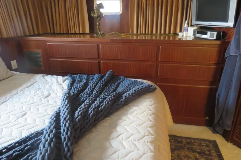 Slide: The Image of Cozy bedroom in 1986 Hatteras 58 Motor Yacht with wood cabinetry and knit blanket. - 37
