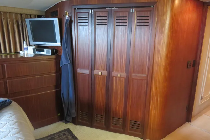 Slide: The Image of 1986 Hatteras 58 Motor Yacht interior with wood paneling, TV, and storage. - 38