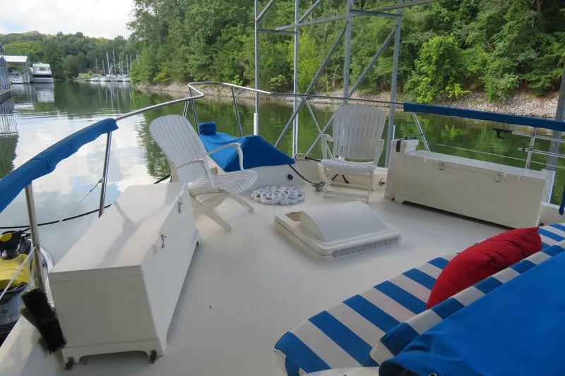 Slide: The Image of 1986 Hatteras 58 Motor Yacht deck with chairs, cushions, and scenic lake view. - 44