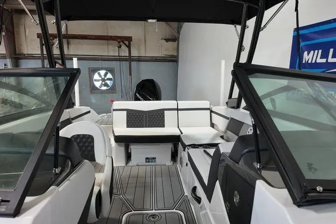 Slide: The Image of 2024 Monterey M-225 boat interior with sleek seating and modern design in a showroom. - 20