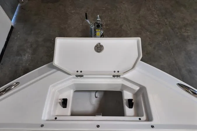 Slide: The Image of 2024 Monterey M-225 boat storage compartment with open lid, showcasing interior space. - 25