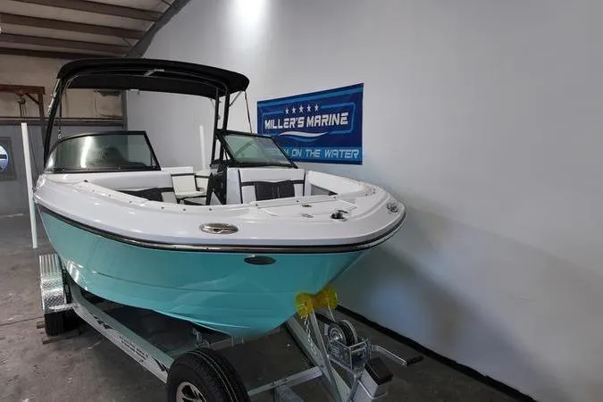 Slide: The Image of 2024 Monterey M-225 boat on trailer in showroom, featuring sleek design and modern features. - 3