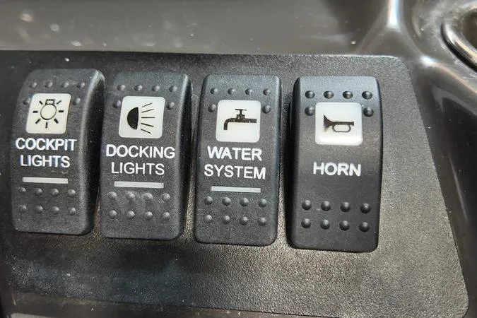 Slide: The Image of Control panel of a 2024 Monterey M-225 boat with cockpit, docking, water, and horn switches. - 32