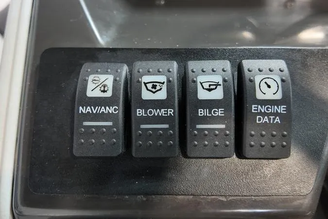 Slide: The Image of Control panel switches on a 2024 Monterey M-225 boat: Navianc, Blower, Bilge, Engine Data. - 33
