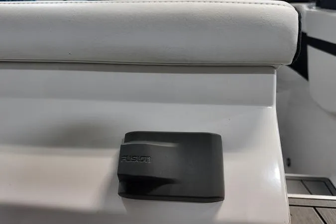 Slide: The Image of 2024 Monterey M-225 boat interior with Fusion audio component on white seating. - 8