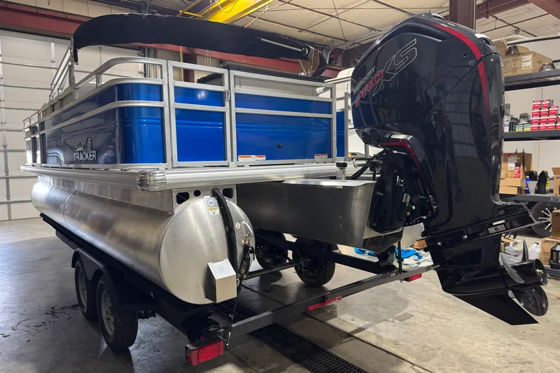 Slide: The Image of 2026 Sun Tracker Fishin' Barge 20 DLX pontoon boat with Mercury Pro XS engine in a garage. - 2