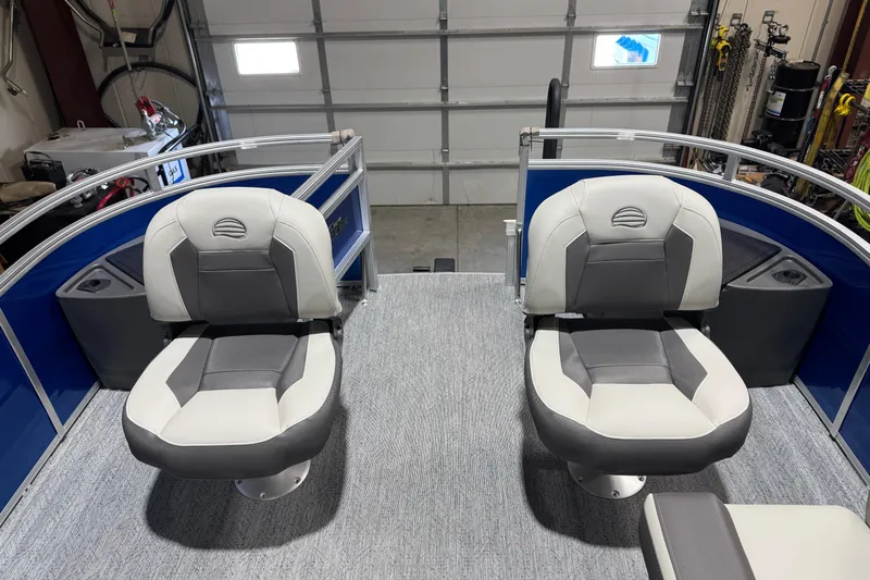 Slide: The Image of 2026 Sun Tracker Fishin' Barge 20 DLX interior with two cushioned seats in a garage setting. - 7